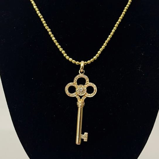 DIJE CON FORMA DE LLAVE EN ORO 18K CON BRILLANTES